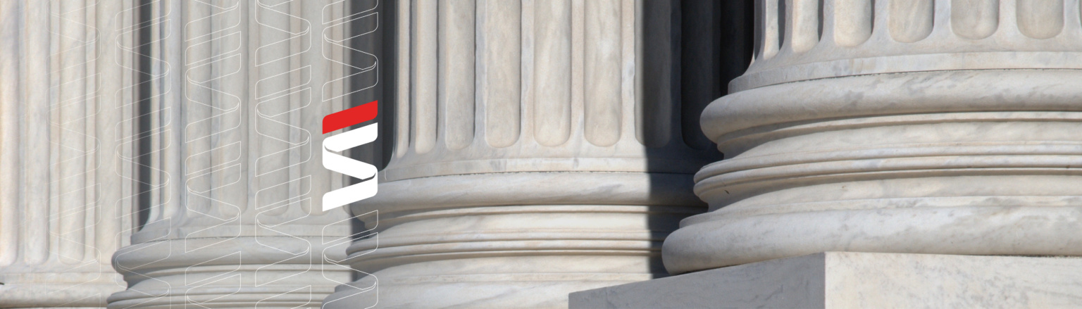 Close-up of stone courthouse columns with vertical fluting. Fraser Stryker logo pattern on the left side.