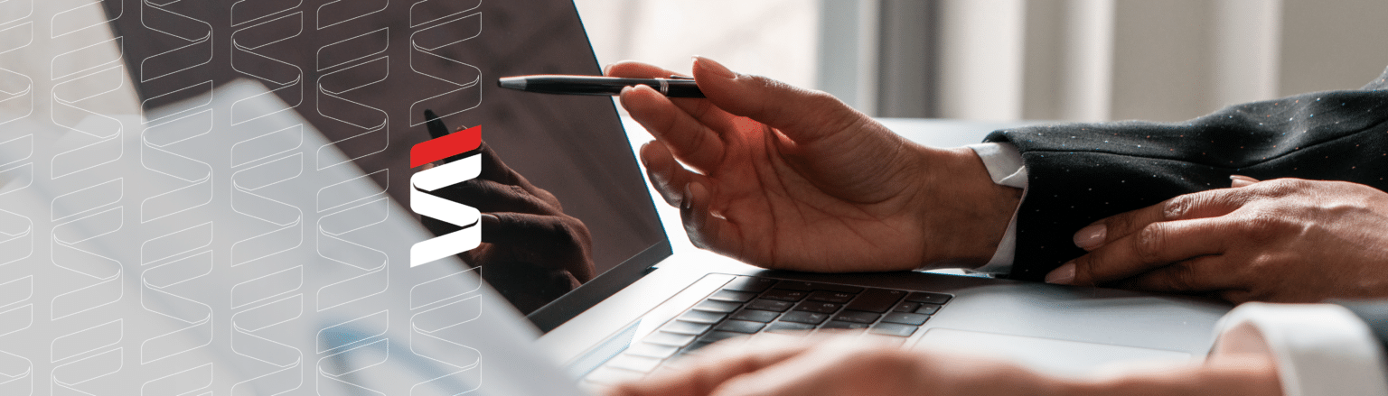 Two professionals engaged in a business discussion, one pointing with a pen while the other holds a document, with a laptop in the foreground. Fraser Stryker logo icon repeating on the left side of the photo.