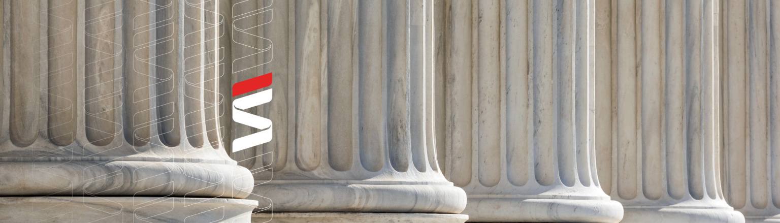 Close-up of stone courthouse columns with vertical fluting. Fraser Stryker logo pattern on the left side.