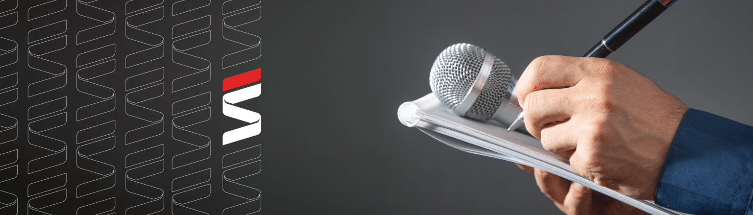 Hand holding mic, notepad and pen. Fraser Stryker logo icons repeating on the left side of the photo.