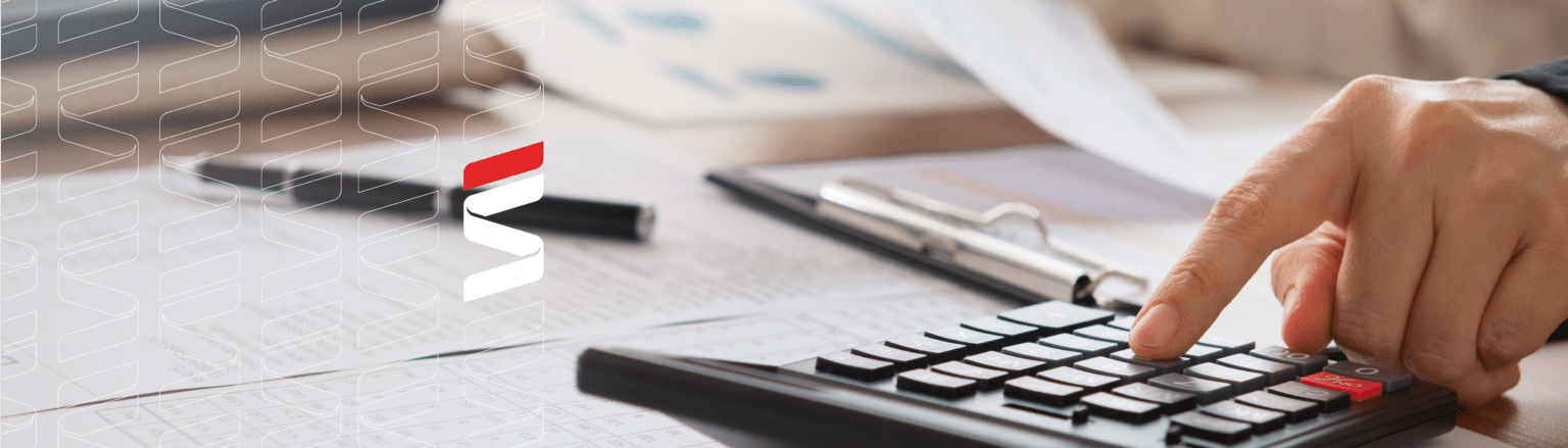 Close up photo of person at desk typing on a calculator and looking at a piece of paper. Fraser Stryker logo icon repeating on to the left side of the photo.