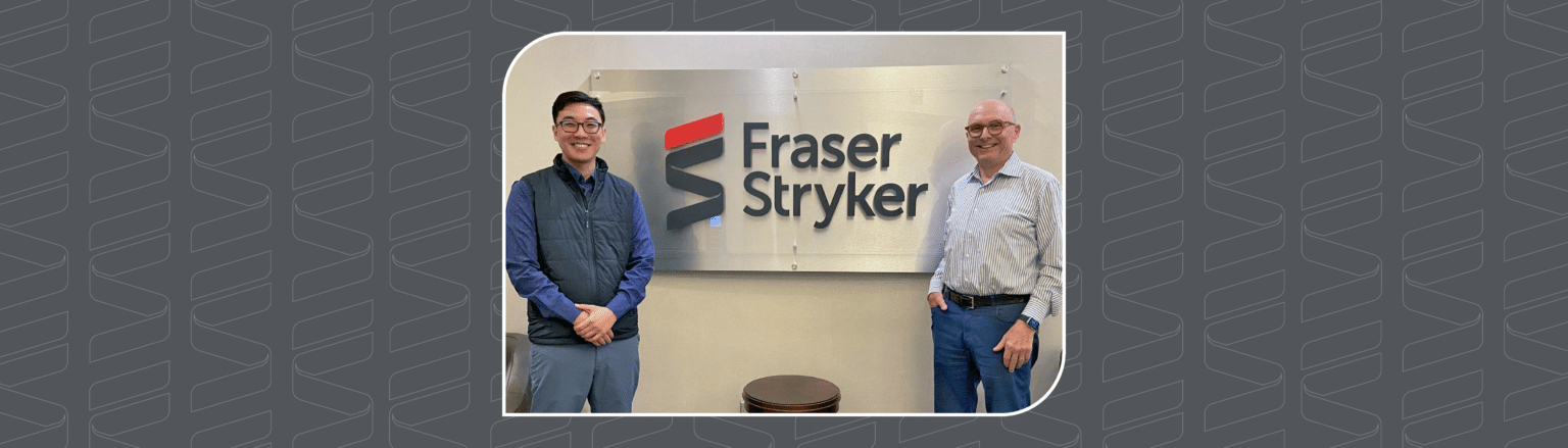 William Wenbo Wang and Stephen Bruckner posing outside of the Fraser Stryker lobby sign. The photo is inside of an icon with repeating Fraser Stryker logo outlines around it.