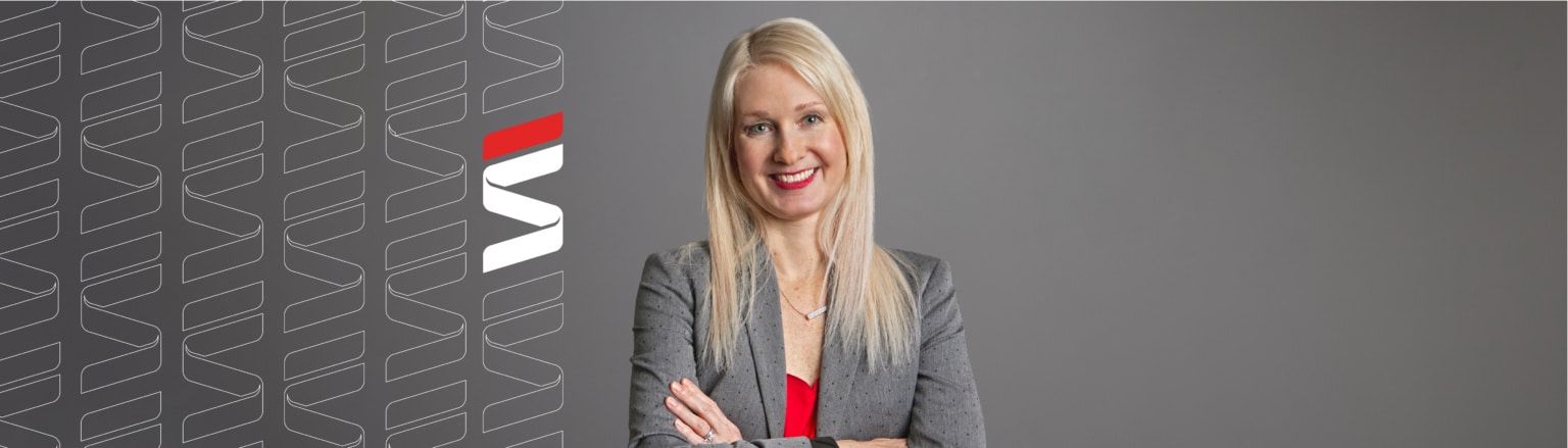 Emily Langdon attorney, wearing grey jacket and red shirt. Fraser Stryker logo icon repeating on the left side of the photo.