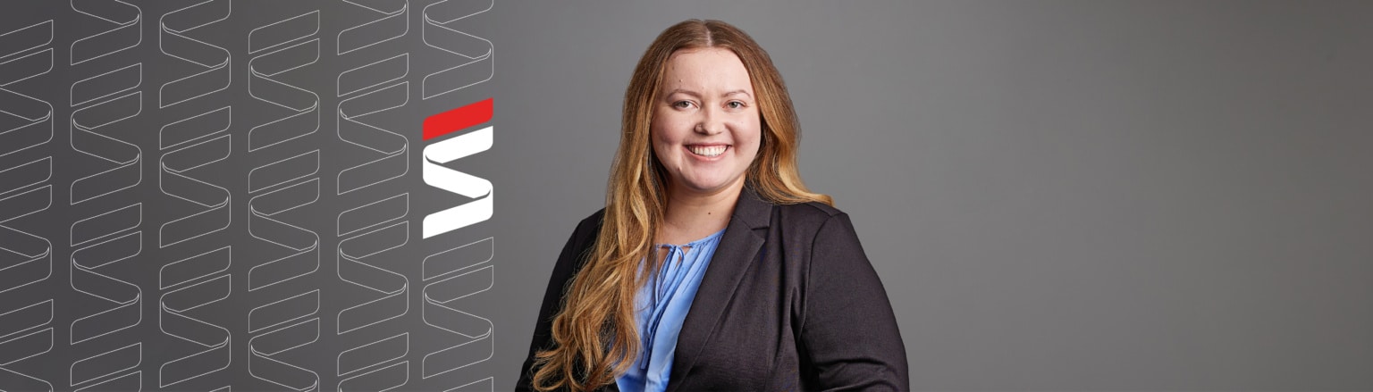 Photo of Makynna Montgomery, wearing a blue shirt and a black suit coat. Fraser Stryker logo icon repeating on the left side of the photo.
