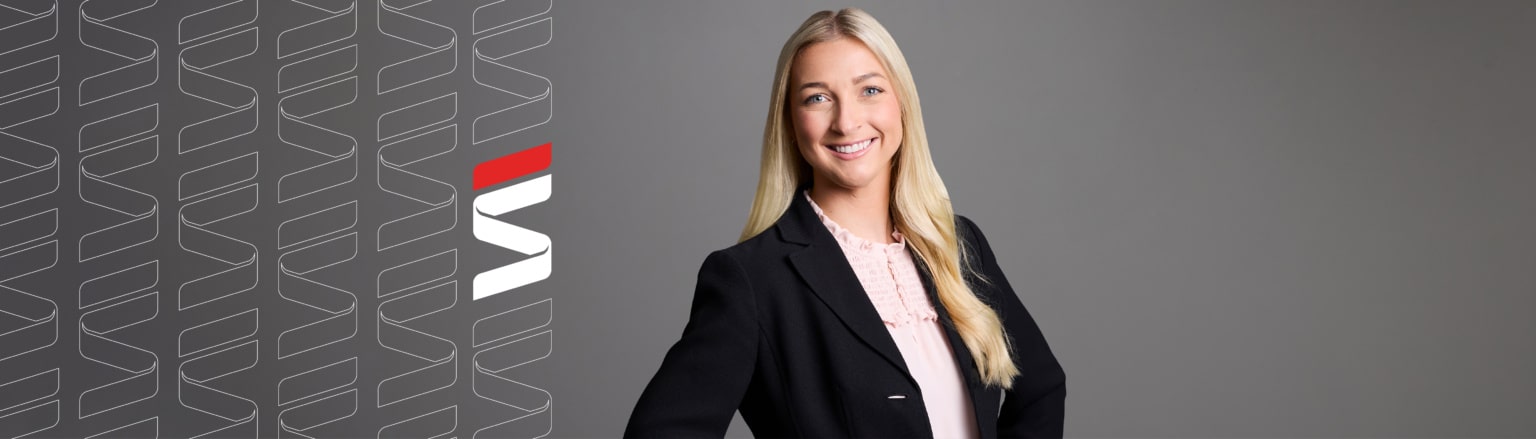 Heidi Mickelson, Fraser Stryker attorney, wearing a black suit jacket and a pink shirt. Fraser Stryker logo icon repeating on the left side of the photo.