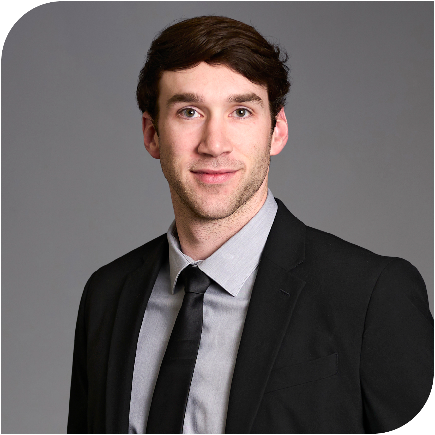 Cooper Nally, Fraser Stryker Summer Associate, wearing a black jacket, grey button down shirt, and black tie
