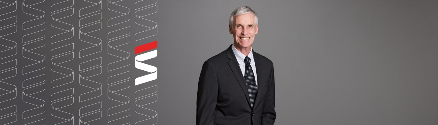 David Anderson, Fraser Stryker attorney, wearing a black jacket, white patterned shirt button down shirt, and blue patterned tie. Fraser Stryker logo pattern on the left side.