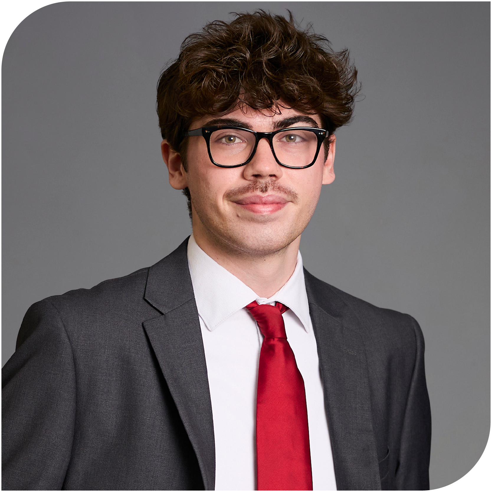 Sam Spethman, Fraser Stryker Summer Associate, wearing a grey jacket, white button down shirt, and red tie