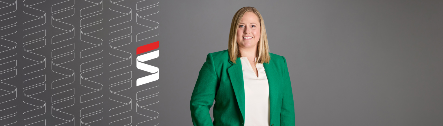 Amelia Prickett Wiesen, Fraser Stryker attorney, wearing a green jacket and white shirt shirt. Fraser Stryker logo pattern on the left side.