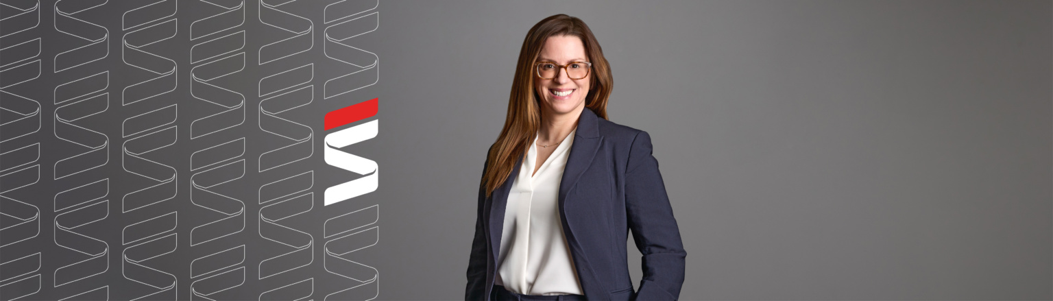 Ann Zebrowski, Fraser Stryker attorney, wearing a navy blue jacket, navy blue pants, and white shirt. Fraser Stryker logo pattern on the left side.