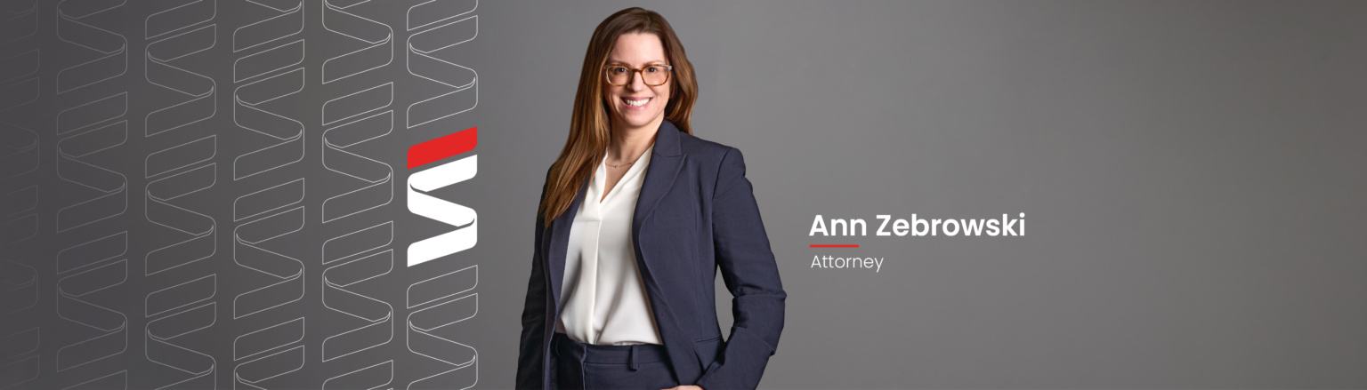 Ann Zebrowski, Fraser Stryker attorney, wearing a navy blue jacket, navy blue pants, and white shirt. Fraser Stryker logo pattern on the left side.