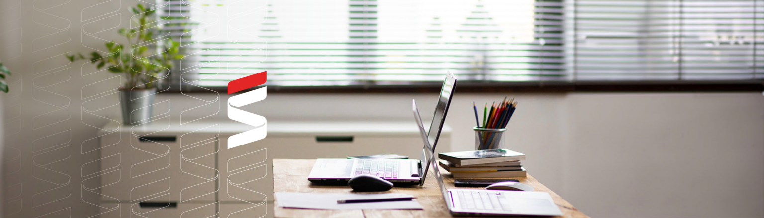 Photo of desk with two laptops, mouse, books, pens and notepad. Fraser Stryker logo icon repeating on the left side of the photo.