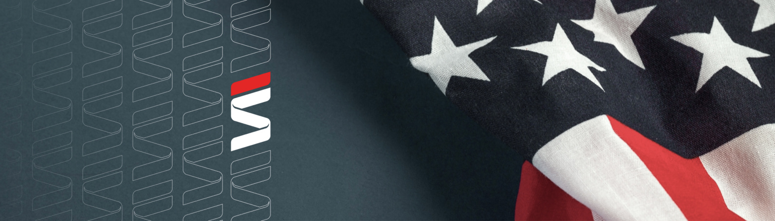 A close-up view of an American flag with stars and stripes, partially draped on a dark background. Fraser Stryker logo icon repeating on the left side of the photo.